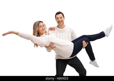 Felice giovane uomo che porta una giovane donna nelle sue braccia isolati su sfondo bianco Foto Stock