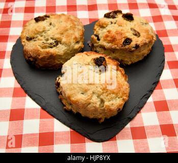 3 scones su un cuore pezzo sagomato di ardesia. Foto Stock