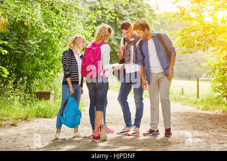 Gruppo di adolescenti escursionismo con mappa in estate nella natura Foto Stock