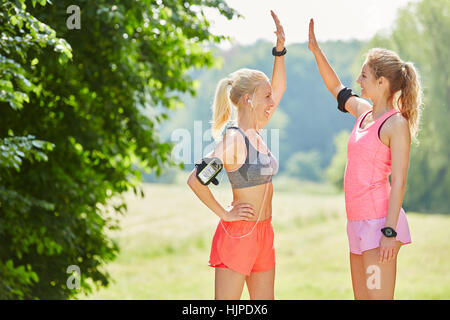 Due donna dando alta cinque in aria per ogni altro come segno di successo e motivazione Foto Stock