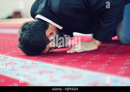 Giovane uomo musulmano in preghiera nella moschea colorati Foto Stock