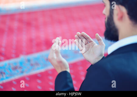 Giovane uomo musulmano in preghiera nella moschea colorati Foto Stock