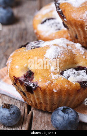 Deliziosi e freschi muffin ai mirtilli sul tavolo di legno macro verticale. Foto Stock