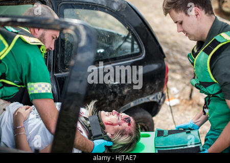 I paramedici vettura in movimento crash vittima sulla barella Foto Stock