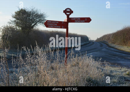 Dorset segnavia rosso. Pesante la brina e il ghiaccio nero sulla strada tra Charlton Horethorne e Sherborne in Dorset, Inghilterra. Foto Stock