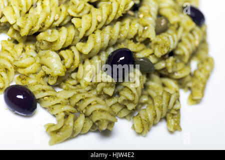 Fusilli conditi con il pesto, olive nere e capperi. Pasto pronto da mangiare Foto Stock