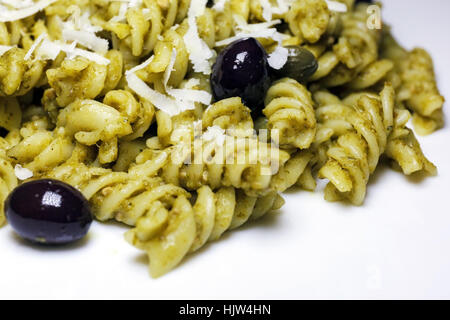 Fusilli conditi con il pesto, olive nere e capperi. Pasto pronto da mangiare Foto Stock