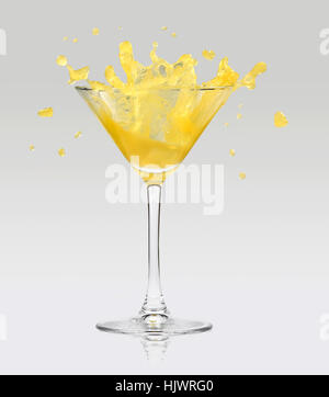 Succo di arancia schizzi di vetro. Isolato su sfondo grigio. Foto Stock