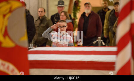 Un giovane uomo rende omaggio all'ex astronauta e senatore americano John Glenn, giacendo in riposo sotto una guardia d'onore dei Marine degli Stati Uniti nella Ohio Statehouse Rotunda a Columbus, Ohio, il 16 dicembre 2016. Foto Stock