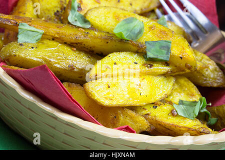 Vegana Vegetariana/Bombay speziata cotta Spicchi di patate servita in un cestino. Foto Stock