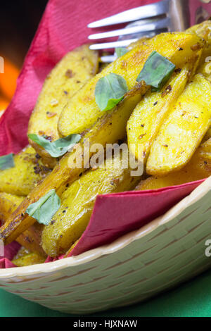 Vegana Vegetariana/Bombay speziata cotta Spicchi di patate servita in un cestino. Foto Stock