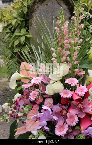 Bouquet de fleurs sur une pierre tombale. Foto Stock