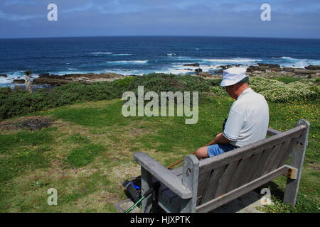 Il vecchio uomo si siede accanto al mare profondo nel pensiero immagine in formato paesaggio con spazio di copia Foto Stock