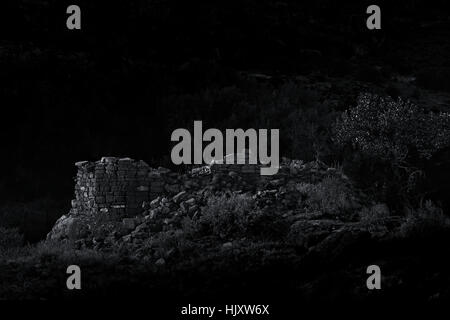 Drammatica B&W foto di un caduto Anasazi torre al chiaro di luna. Foto Stock