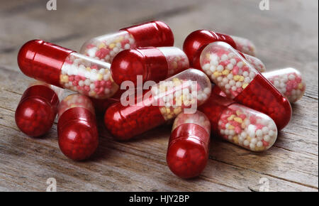 Macro di rosso le pillole di medici su sfondo di legno Foto Stock