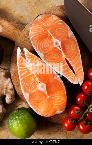 Alimenti per pesci sfondo sulla tavola di marmo con pomodori ciliegia , avocado, calce, lo zenzero Foto Stock