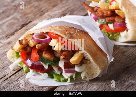 Shawarma in pane pita avvolto nella carta da vicino sul tavolo orizzontale Foto Stock