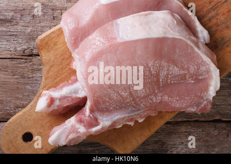 Due pezzi di carne cruda bistecca di carne di maiale su un tagliere close up Foto Stock