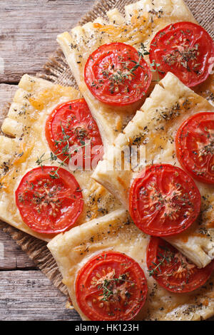 Pasta sfoglia con pomodoro e formaggio sulla tabella di close-up verticale. vista superiore Foto Stock