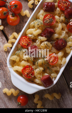 Pasta con pomodorini e salsicce di close-up vista da sopra e ingredienti verticale. Foto Stock