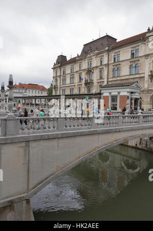 LJUBLJANA, Slovenia - 04 settembre 2015: pedoni a piedi lungo il triplo ponte sul fiume Ljubljanica. Lubiana è la più grande città e capitale di Sl Foto Stock