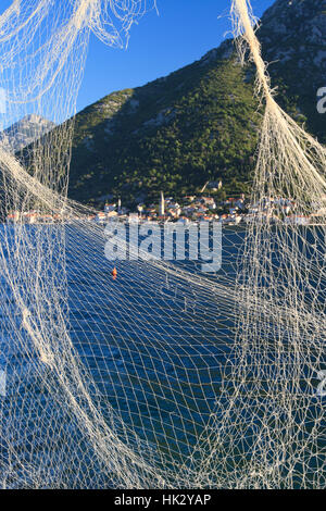 Splendida vista della Baia di Kotor attraverso la rete da pesca. verticale, Montenegro Foto Stock