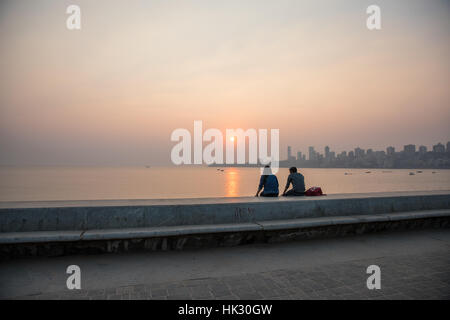Le coppie guardare il tramonto sulla spiaggia Chowpaty in Mumbai (Bombay), India. Foto Stock