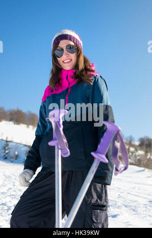 Ragazza con i bastoni per escursioni su montagne coperte di neve Foto Stock