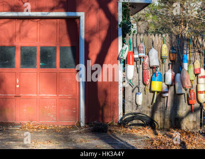 Un vecchio garage con boe appeso su una recinzione stockade in inverno il sole Foto Stock