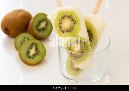 Yogurt fatto in casa ghiaccio popsicles con fresche kiwi per le calde giornate estive su un tavolo bianco Foto Stock