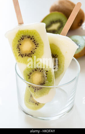 Yogurt fatto in casa ghiaccio popsicles con fresche kiwi per le calde giornate estive su un tavolo bianco Foto Stock