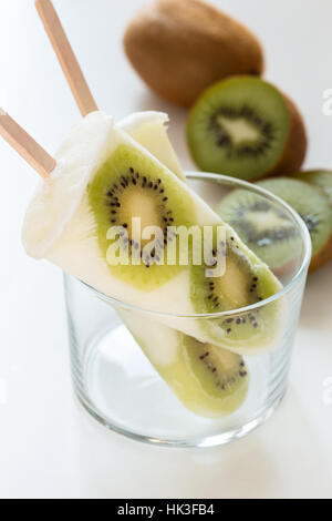 Yogurt fatto in casa ghiaccio popsicles con fresche kiwi per le calde giornate estive su un tavolo bianco Foto Stock