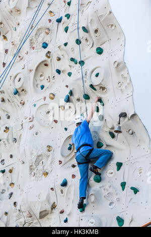 Uomo di mezza età sulla parete di arrampicata Foto Stock