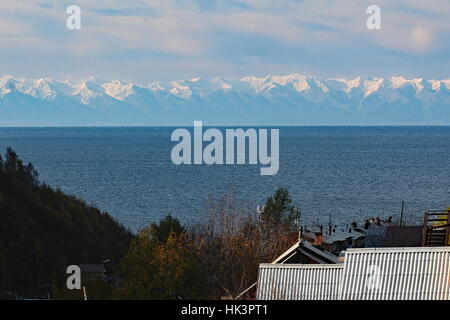 Listvyanka sul lago Baikal in Russia cercando in tutta verso le montagne ricoperte neve Foto Stock