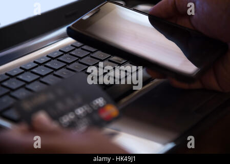 Messa a fuoco selettiva su laptop online il pagamento mobile internet banking concetto nel buio di basso tono tasto Foto Stock