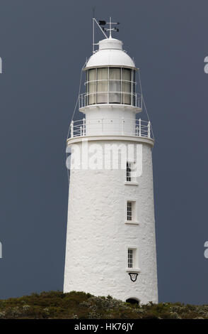 Un edificio bianco di Cape Bruny Lighthouse contrastando contro lo sfondo scuro di nuvole di tempesta Foto Stock