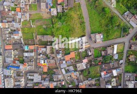Una fotografia aerea dall'alto cattura un fitto quartiere residenziale caratterizzato da un mix di bassi edifici con vari colori e materiali del tetto. La zona include strade strette, alcune con Foto Stock