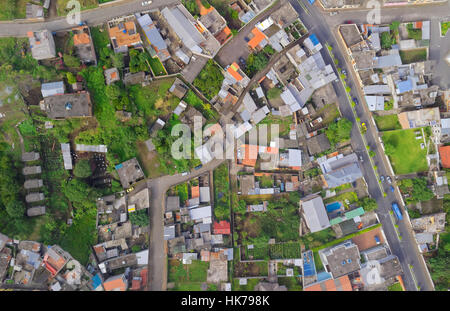 Una fotografia aerea dall'alto cattura un'area residenziale densamente costruita con un mix di case con vari tipi di tetto, tra cui metallo, piastrelle e cemento. Il quartiere è inframmezzato Foto Stock