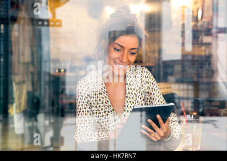 Donna che utilizza un Tablet PC in Coffee shop Foto Stock
