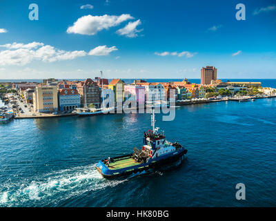 Rimorchiatore a traino e colorati di fila di case nel quartiere di Punda sul retro, commerciale arcade, Waterfront, Sito del Patrimonio Mondiale, Willemstad Foto Stock