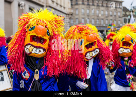 Mascherare gli uomini e le donne si stanno unendo la grande sfilata di Carnevale di Basilea, uno degli eventi più spettacolari Foto Stock