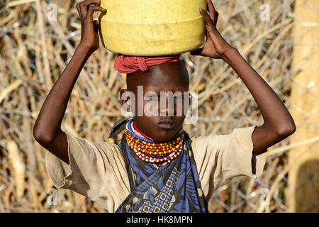 KENYA Turkana, Lodwar, villaggio Turkana Kaitese, Turkana ragazza trasportare acqua da oltre dicstances lunga a causa della siccità Foto Stock