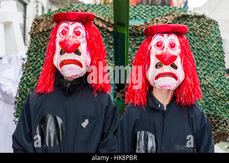 Mascherare gli uomini e le donne si stanno unendo la grande sfilata di Carnevale di Basilea, uno degli eventi più spettacolari Foto Stock