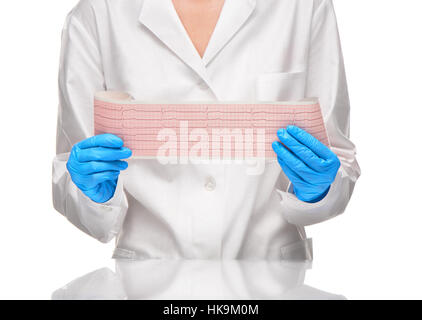 Medico donna in abito bianco e guanti blu holding risultati ECG su un foglio di carta contro uno sfondo bianco Foto Stock