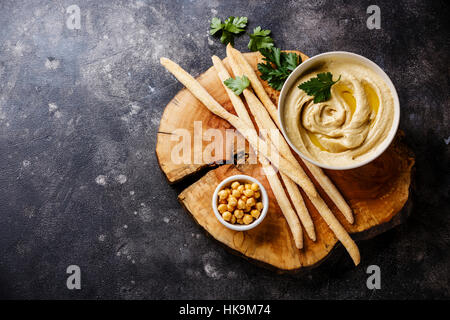 In casa hummus con bastoncini di pane e prezzemolo su pietra sfondo spazio di copia Foto Stock