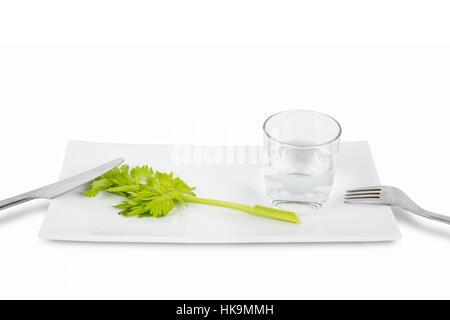 Gambo di sedano e un bicchiere di acqua isolati su sfondo bianco. Simbolo di disordine alimentare e anoressia. Foto Stock