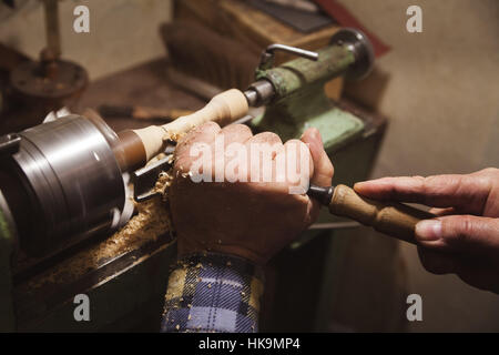 Uomo con le mani in mano in attesa vicino a scalpello tornio Foto Stock