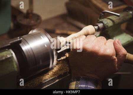 Uomo con le mani in mano in attesa vicino a scalpello tornio Foto Stock