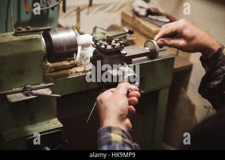 Uomo con le mani in mano in attesa vicino a scalpello tornio Foto Stock