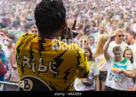 Un DJ è animare migliaia di giovani donne e uomini presso il colorato Holi festival Foto Stock